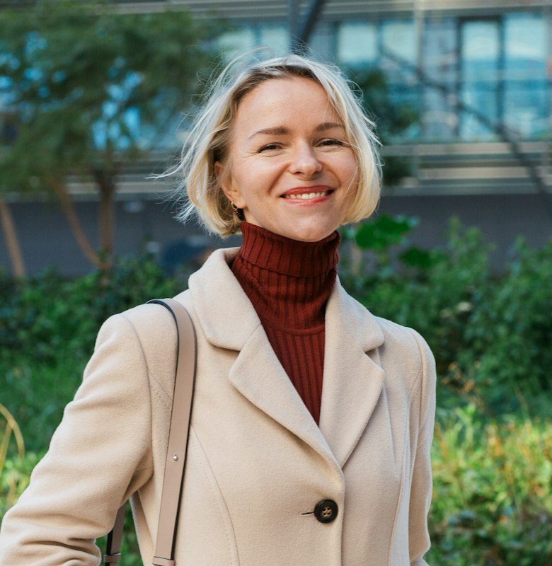 Stylish business woman smiling while standing outdoors in the financial district